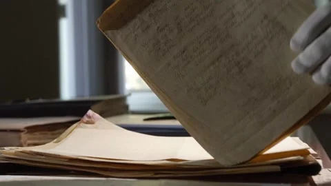 Hands in white gloves leaf through old paper documents on the table 스톡 동영상 243719046