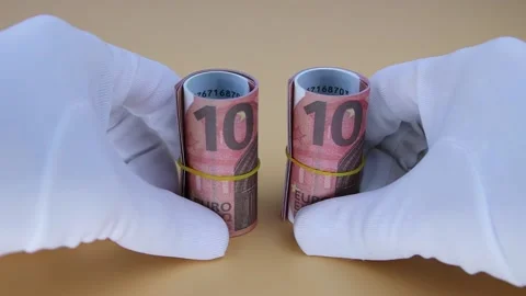 Hands in white gloves move 2 rolled rolls of 10 euro banknotes. Close-up Vídeo Stock 142311060