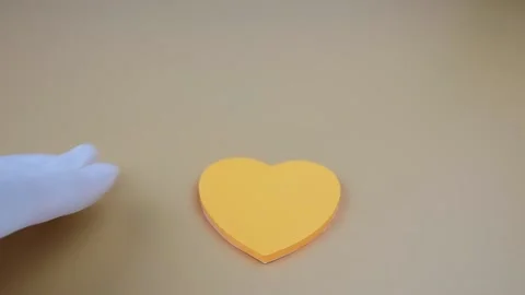 Hands in white gloves place rolled up 100 dollar bills on heart-shaped stickers Vídeo Stock 142193321