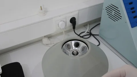 Hands in white gloves put test tubes with blood into laboratory centrifuge Stock Footage 92270253