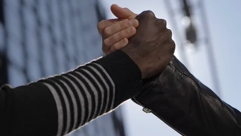 Hands of a white man and a black woman intertwining and greeting-outdoor Stock Footage 104785500