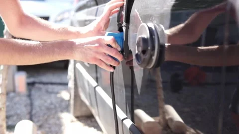 Hands of white man removes blue network plug. Campervan 230v socket. RV Stock Footage 257896376