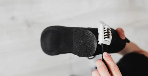 Hands wipe black leather boot Stock Photos