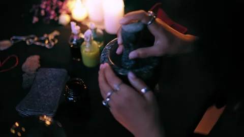 Hands of witch cooking magic potion, pounding ingredients in mortar, healing Stock Footage 179954930