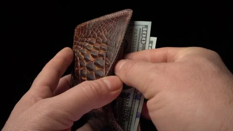 Hands withdrawing cash from a textured leather wallet, showcasing the action of Stock Footage 327011985