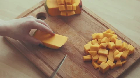 Hands of a woman dicing a mango slice on a chopping board 4K Stock Footage 61752947