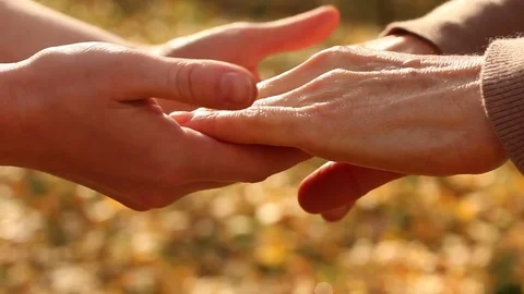 Hands of woman supporting, helping elderly person, coping problems together Stock Footage