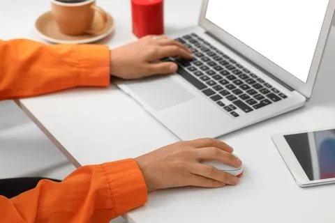 Hands of woman using computer mouse and laptop at table in office Stock Photos