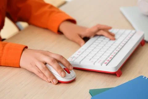 Hands of woman using computer mouse and keyboard at table in office Stock Photos