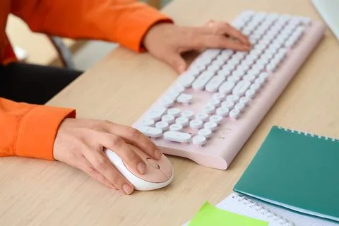 Hands of woman using computer mouse and keyboard at table in office Stock Photos