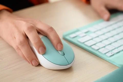 Hands of woman using computer mouse and keyboard at table in office Stock Photos