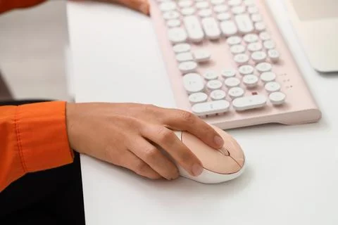 Hands of woman using computer mouse and keyboard at table in office Stock Photos