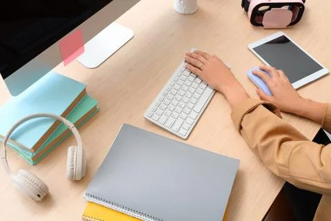 Hands of woman using computer mouse and keyboard at table in office Stock Photos