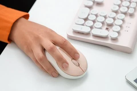 Hands of woman using computer mouse and keyboard at table in office Stock Photos