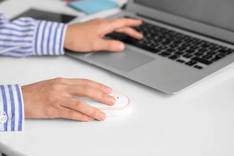 Hands of woman using computer mouse and laptop at table in office Stock Photos