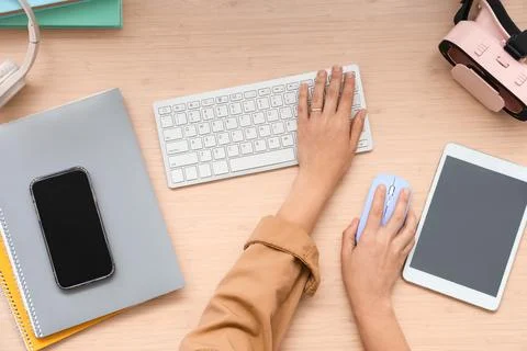 Hands of woman using computer mouse and keyboard at table in office, top view Stock Photos
