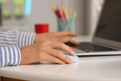 Hands of woman using computer mouse and laptop at table in office Stock Photos
