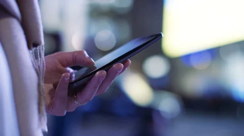 Hands of a woman using her cell phone at night in the city Video stock 58594672