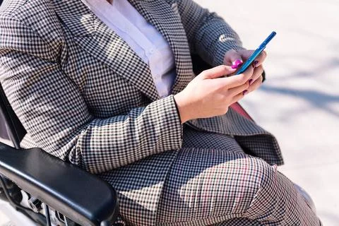 Hands of a woman using wheelchair using phone Foto stock
