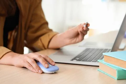 Hands of woman with wireless computer mouse at table in office Stock Photos