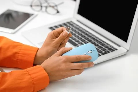 Hands of woman with wireless computer mouse at table in office Stock Photos