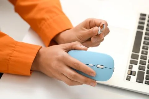 Hands of woman with wireless computer mouse at table in office Stock Photos
