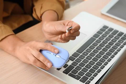 Hands of woman with wireless computer mouse at table in office Stock Photos