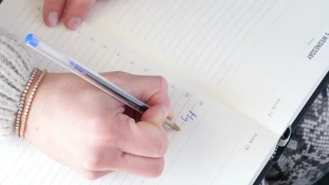 Hands of a woman writing My dear diary in a notebook. Stock Footage