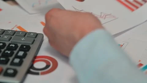 Hands work on a calculator and write with a pen while analyzing paper documents Video stock 338188298