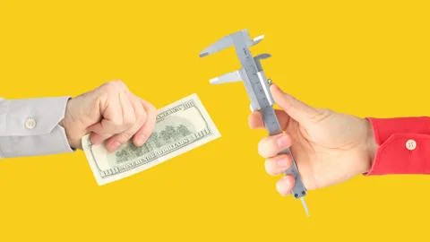 Hands with work tool and money on a orange background. salary. business relat Stock Photos