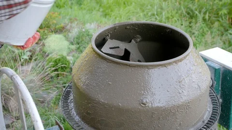 Hands of the worker add dry cement in a concrete mixer a bucket. Concrete 库存影片 95289021