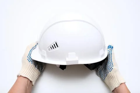 Hands of a worker, builder holding a white protective hard hat, safety helmet Stock Photos
