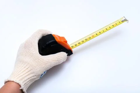 Hands of a worker, builder in protective gloves halding a ruler, using tape Stock Photos