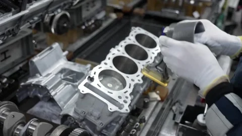 Hands of a worker carefully installing a piston and connecting rod into the Stock Footage 333376631