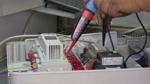 Hands of worker check contacts voltage indicator in electronics in factory. Stock Footage 79772362