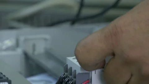 Hands of worker check contacts voltage indicator in electronics in factory. Stock Footage 79772474