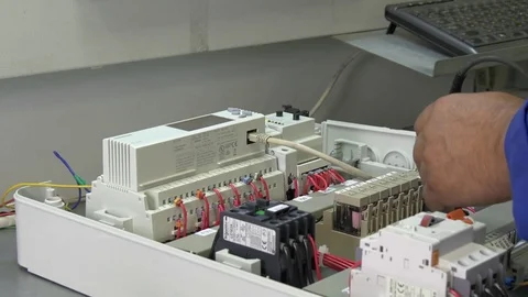 Hands of worker check contacts voltage indicator in electronics in factory. Stock Footage 79772611