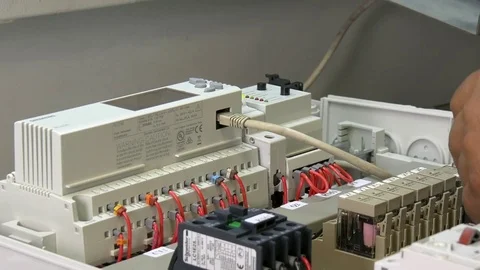 Hands of worker check contacts voltage indicator in electronics in factory. Stock Footage 82670703