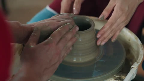 Hands of worker expanding sides of utensil on pottery wheel Stock Footage 304222906