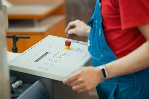 Hands of the worker over the control panel of printing machine Stock Photos