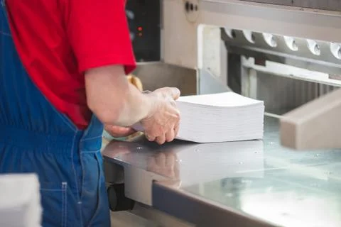 Hands of worker in typography puts the paper stack in the cutter Stock Photos