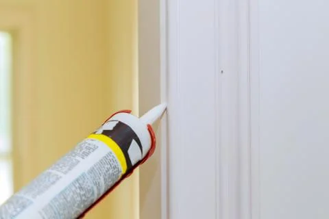 Hands of worker using silicone tube for repairing of molding door trim Stock Photos