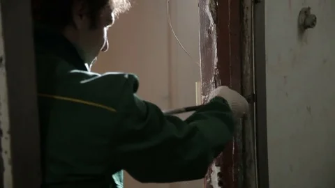Hands of worker who dismantles old door frame using crowbar Video stock 70913675