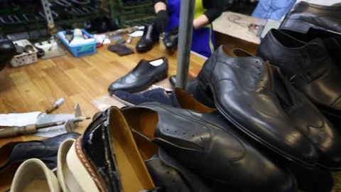 Hands of workers and new shoes in workshop of factory, close-up Stock Footage 80531261