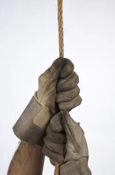 Hands of workers hanging from a rope Stock Photos