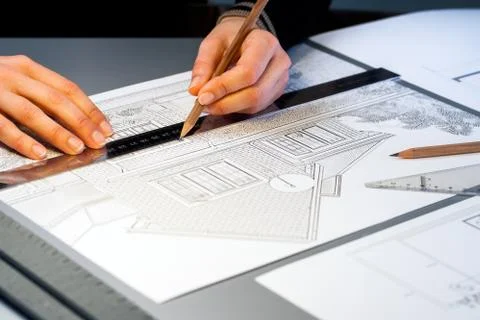 Hands working on architectural documents. Stock Photos