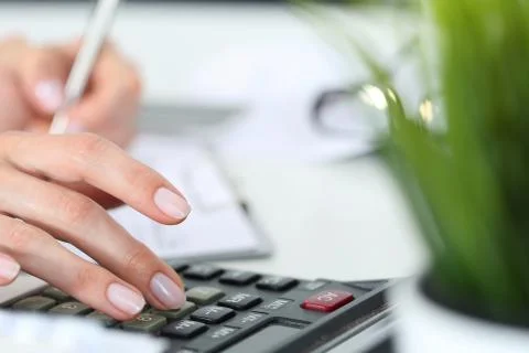 Hands working on the calculator Stock Photos