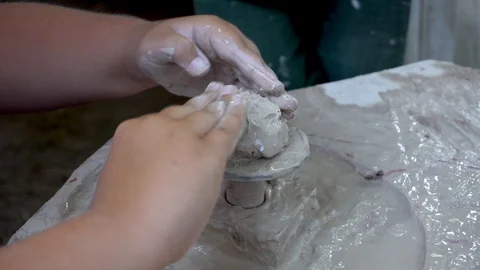 Hands working clay on potter's wheel. Potter shapes the clay product. Close up Stock Footage 129377916