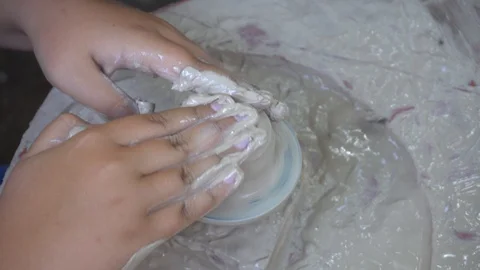 Hands working clay on potter's wheel. Potter shapes the clay product. Stock Footage 129561894
