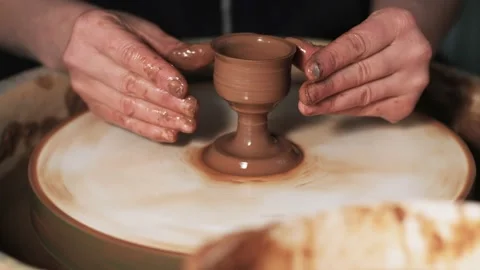 Hands working clay on potter's wheel. Potter shapes the clay product with potter Video stock 144064479